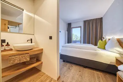a hotel room with a bed and a sink at Appartements Kreuzwegerhof in Lana