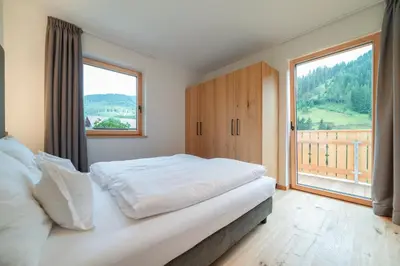 a bedroom with a bed and a large window at Seeberhof in Racines