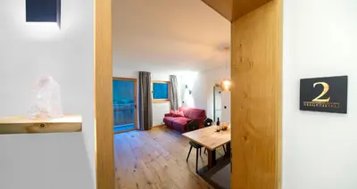 a living room with a table and a red couch at Seeberhof in Racines