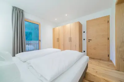 a bedroom with two white beds and a door at Seeberhof in Racines