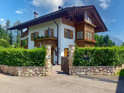 a large house with a wooden roof at Mansarda Le Genziane di Fiemme in Cavalese
