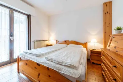 a bedroom with a large bed and a large window at Cesa Alpes 3 in Campitello di Fassa