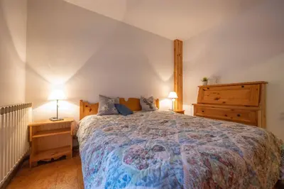 a bedroom with a bed and a dresser and two lamps at Cesa Alpes 3 in Campitello di Fassa