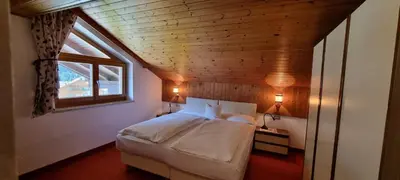a bedroom with a bed in a room with a window at Cesa Fortunato in Canazei