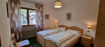 a bedroom with a bed and a window at Cesa Fortunato in Canazei