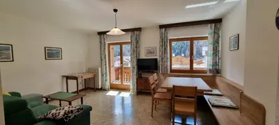 a living room with a couch and a table and a tv at Cesa Fortunato in Canazei
