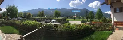 a fence in front of a parking lot with cars at Hernegg Apartment in Riscone