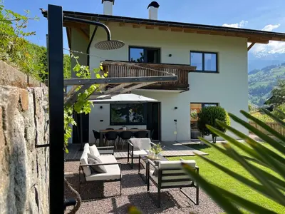 a house with a patio with a table and chairs at Villa Vitis in Rifiano