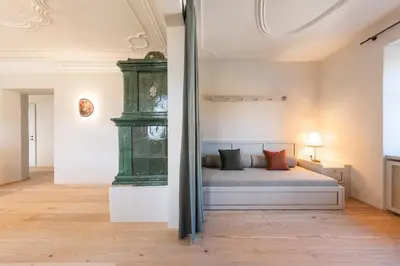 a bedroom with a bed and a green cabinet at Smart Suites Kaltern - Apartments am Kalterer See in Caldaro