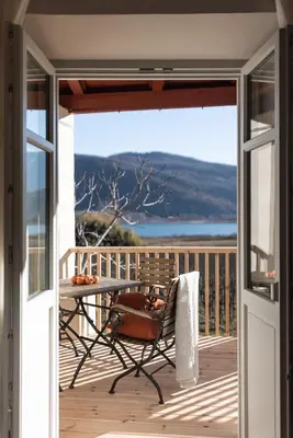 an open door to a balcony with a table at Smart Suites Kaltern - Apartments am Kalterer See in Caldaro