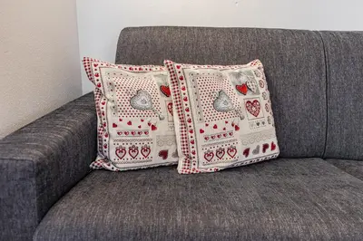 two pillows sitting on a gray couch at Appartamento Césa Ines in Arabba