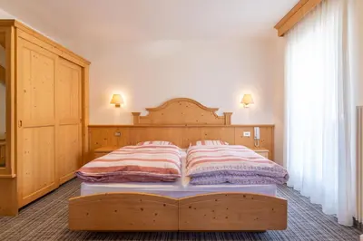 a bedroom with a bed with a book on it at Albergo Canazei in Canazei