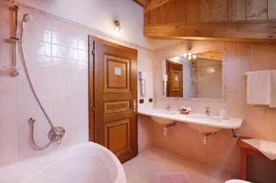 a bathroom with a tub and a sink and a bath tub at Hotel Leonardo in Moena