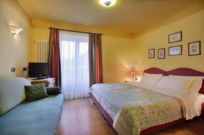 a hotel room with a large bed and a couch at Hotel Leonardo in Moena