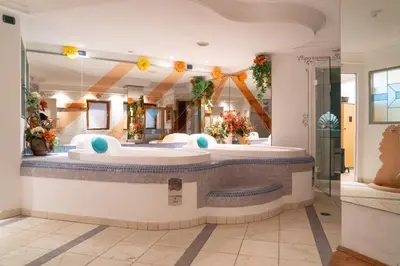 a large bathroom with a tub and a large mirror at Hotel Leonardo in Moena
