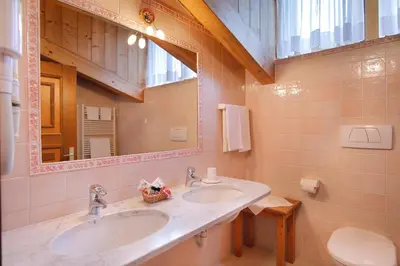 a bathroom with two sinks and a mirror at Hotel Leonardo in Moena
