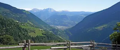 a view of a mountain valley from a wooden fence at Ferienwohnung Maiernhof Bauernhof Ultental in San Pancrazio dʼUltimo