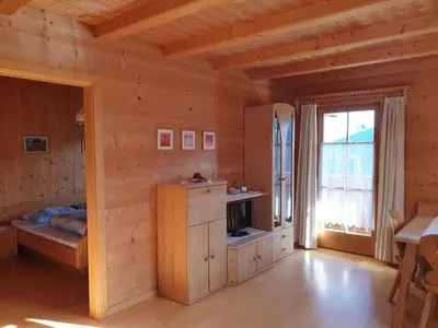 a wooden room with a bed and a window at Ferienwohnung Maiernhof Bauernhof Ultental in San Pancrazio dʼUltimo