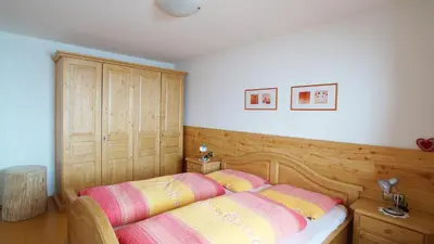a bedroom with a bed with two pillows on it at Ferienwohnung Maiernhof Bauernhof Ultental in San Pancrazio dʼUltimo