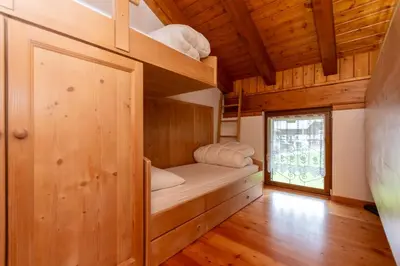 a room with a bunk bed and a window at Residence Molin in Rocca Pietore