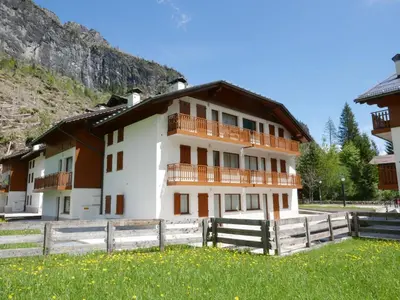 a building with a wooden fence in front of it at Residence Molin in Rocca Pietore