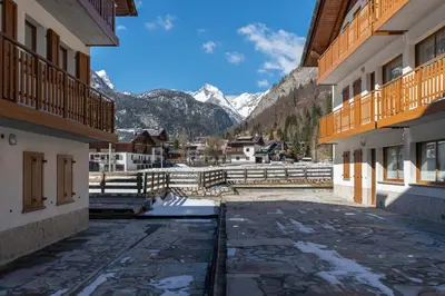 a courtyard of a building with mountains in the background at Residence Molin in Rocca Pietore