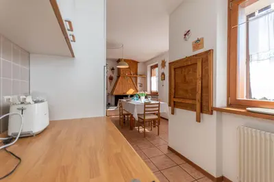 a kitchen and dining room with a table and a window at Maison Villagrande in Colle Santa Lucia