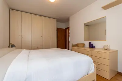 a bedroom with a large white bed and cabinets at Maison Villagrande in Colle Santa Lucia