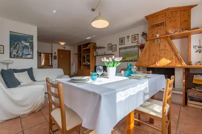 a kitchen and living room with a table and chairs at Maison Villagrande in Colle Santa Lucia
