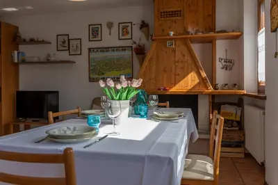 a table with a white table cloth and flowers on it at Maison Villagrande in Colle Santa Lucia