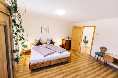 a bedroom with a bed and a wooden floor at Stimpflhof in Aldino