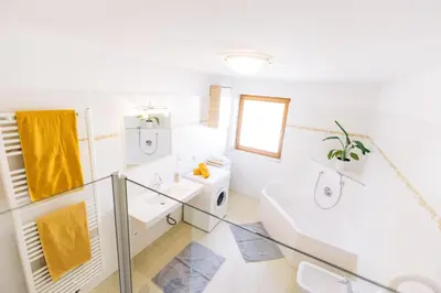 a white bathroom with a sink and a toilet at Stimpflhof in Aldino