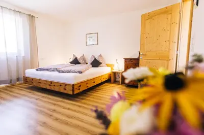a bedroom with a bed and flowers in a room at Stimpflhof in Aldino