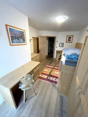a room with a bed and a desk in it at Ciasa Rossi in Soraga