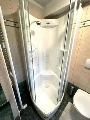 a shower stall in a bathroom with a toilet at Ciasa Rossi in Soraga