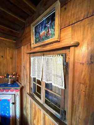 a window in a wooden wall with a picture of chickens at Ciasa Rossi in Soraga