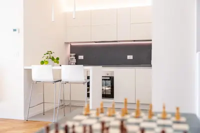 a kitchen with white cabinets and a counter with stools at Italyescapes Emma 11 in Merano