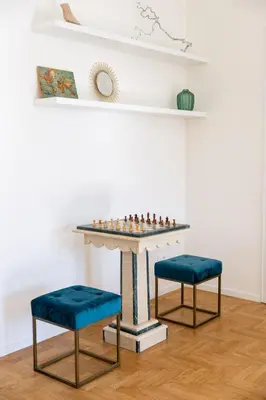 a chess table and two stools in a room at Italyescapes Emma 11 in Merano