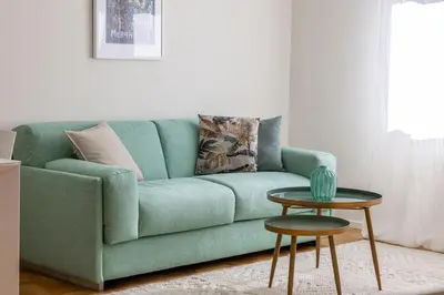 a green couch in a living room with a table at Italyescapes Emma 11 in Merano