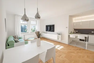 a white kitchen and living room with a white table at Italyescapes Emma 11 in Merano