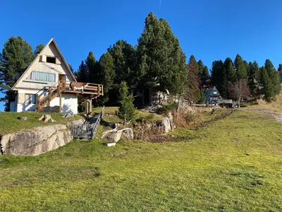 a house with the sunset in the background at Cozy Mountain Chalet in Cavalese