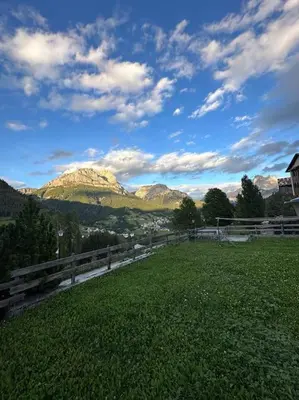 a field with a fence and mountains in the background at Tabia studio - Colle Santa Lucia in Villagrande