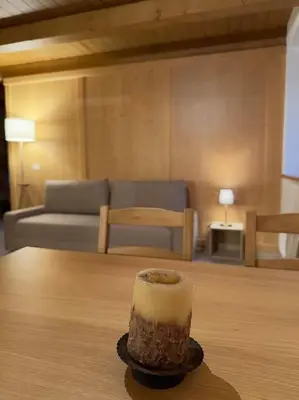 a candle sitting on a table in a living room at Tabia studio - Colle Santa Lucia in Villagrande