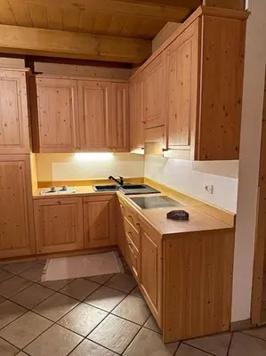 a kitchen with wooden cabinets and a stove top oven at Tabia studio - Colle Santa Lucia in Villagrande