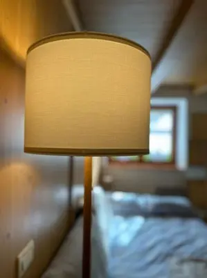 a lamp sitting next to a bed in a room at Tabia studio - Colle Santa Lucia in Villagrande