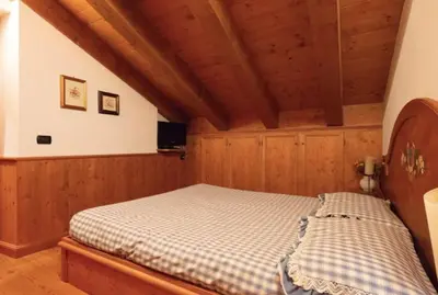 a bedroom with a bed in a room with wooden walls at Mansarda su due livelli nel cuore delle Dolomiti in San Vito di Cadore