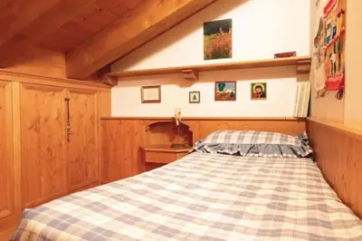 a bedroom with a checkered bed in a room at Mansarda su due livelli nel cuore delle Dolomiti in San Vito di Cadore