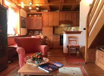 a kitchen with a couch and a table in a room at Mansarda su due livelli nel cuore delle Dolomiti in San Vito di Cadore