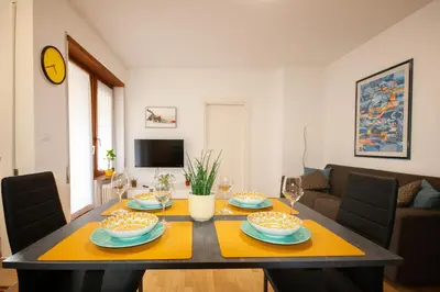 a living room with a table with plates and wine glasses at Tranquillo bilocale vicino al centro storico in Bolzano