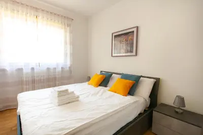 a bedroom with a large white bed with yellow pillows at Tranquillo bilocale vicino al centro storico in Bolzano